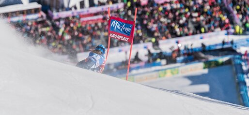 Eine Skirennläufern fährt um ein Tor herum, im Hintergrund die Zuschauer am Zieleinlauf. | © Harald Wisthaler