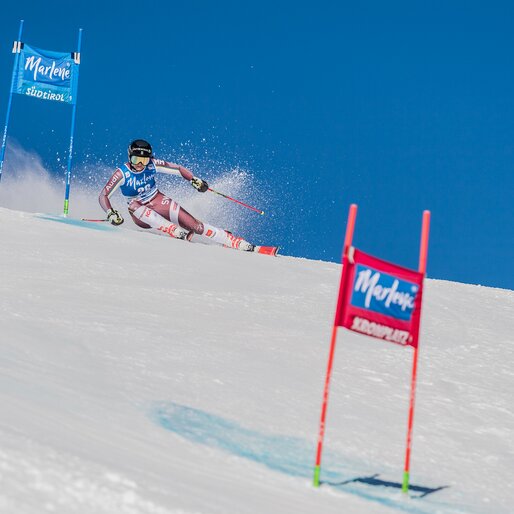Eine Skifahrerin zwischen zwei Slalomtoren unter strahlend blauem Himmel. | © Harald Wisthaler
