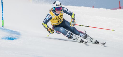 Eine Skirennläuferin umfährt stark in die Kurve gelehnt ein Slalomtor. | © Gianvito Coco