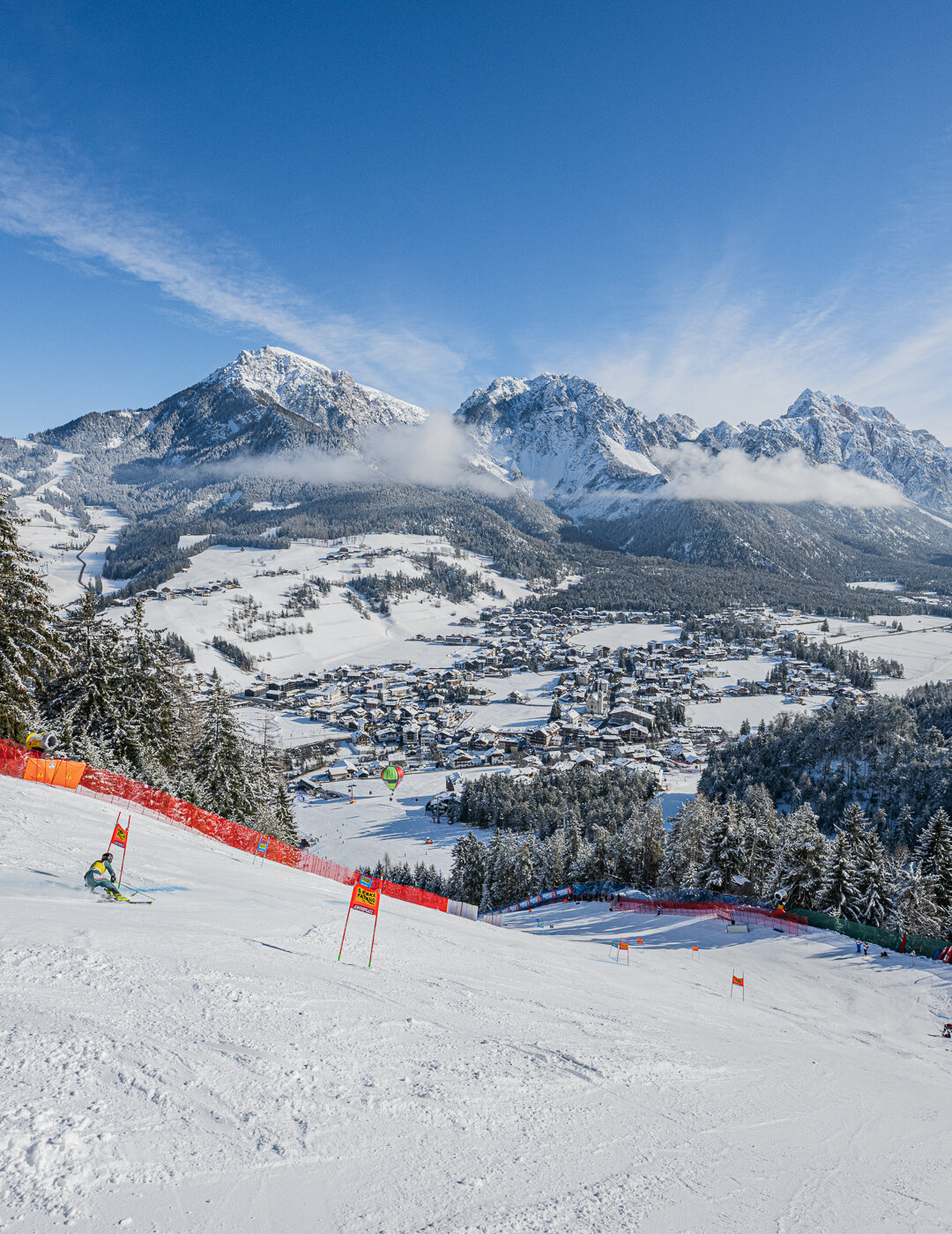 Eine Skirennläuferin beim Riesentorlauf , im Hintergrund die Dolomiten und schneebedeckte Bäume. | © Harald Wisthaler