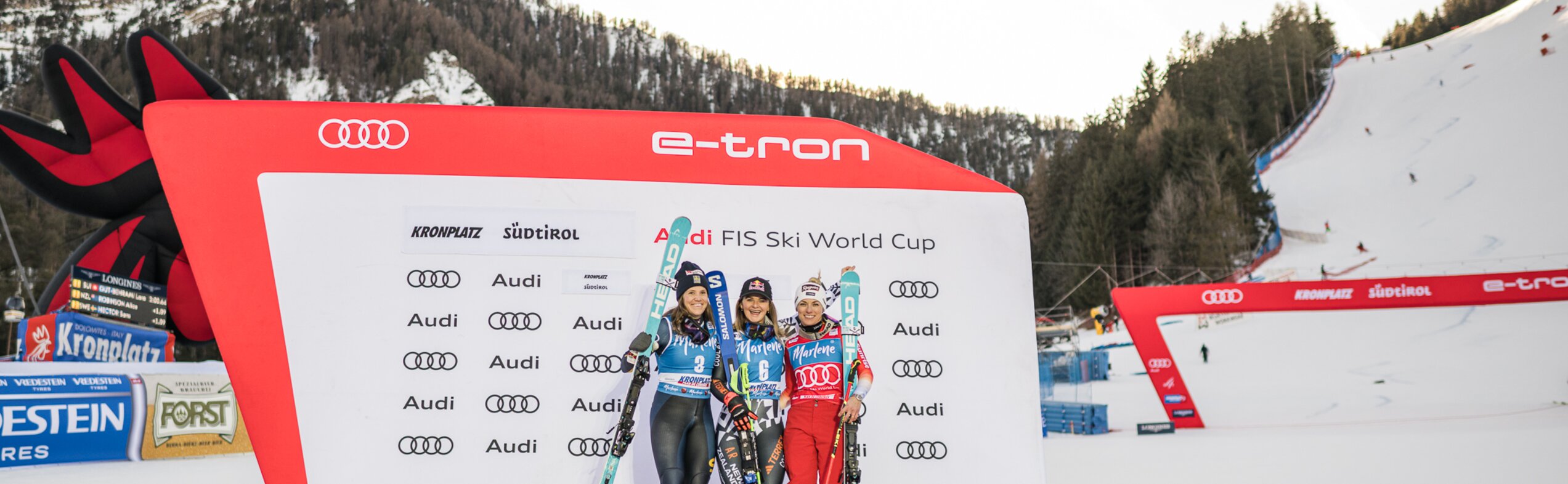 Drei Skifahrerinnen posieren gemeinsam auf dem Siegerpodest im Zielbereich. | © Harald Wisthaler