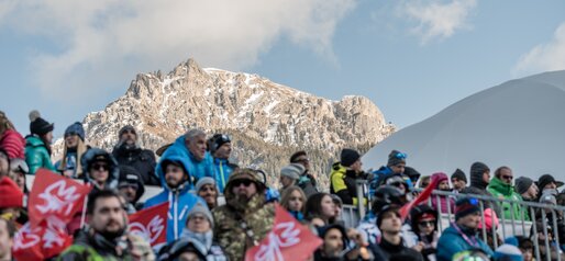 Bei kühlen Temperaturen und mit den verschneiten Dolomiten im Hintergrund wartet das Publikum auf der Tribüne. | © Gianvito Coco