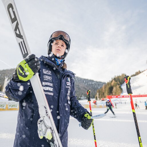 Konzentrierte Athletin hält im Zielbereich ihre Ski und Stöcke. | © Harald Wisthaler
