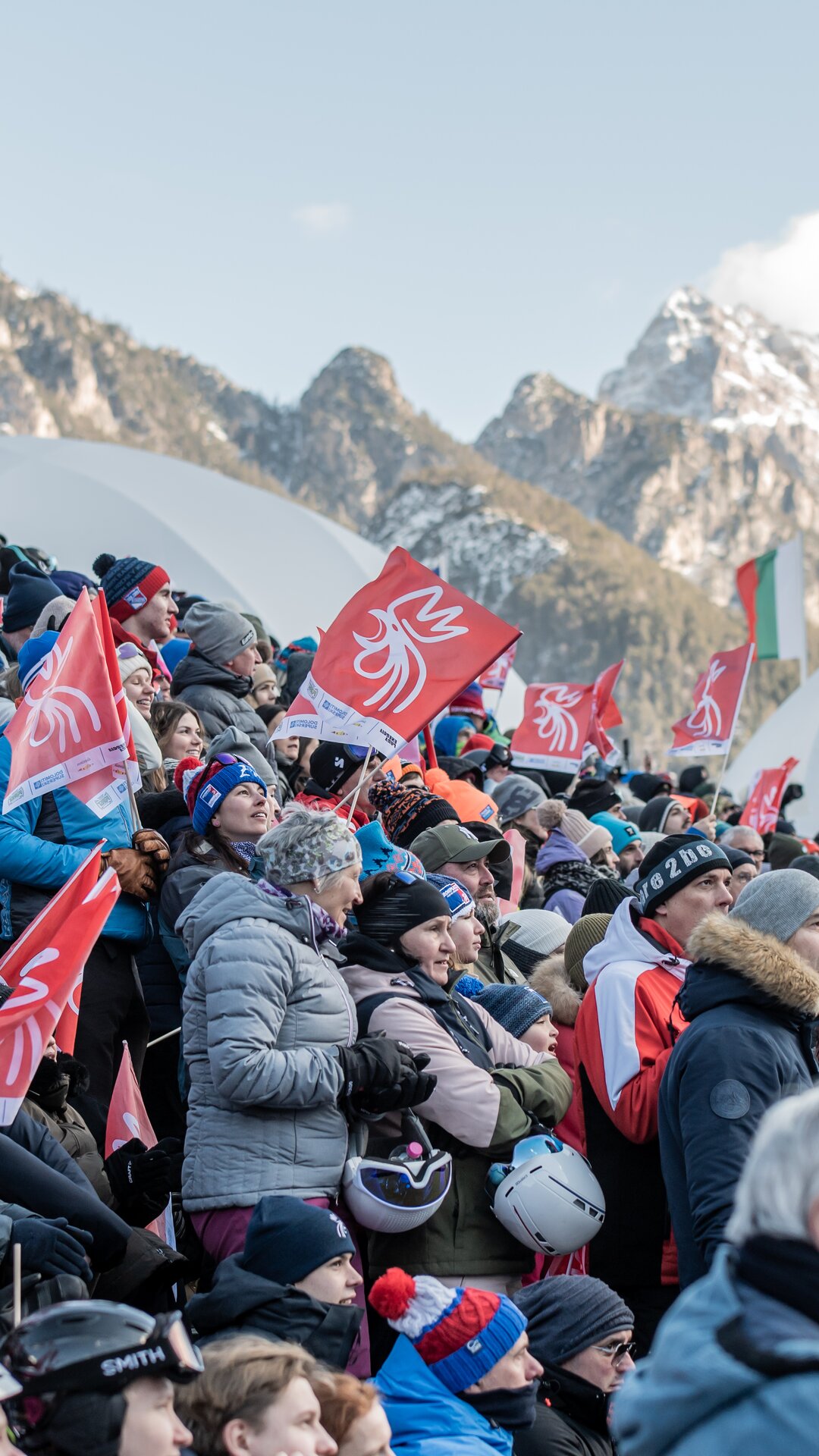 Die Zuschauer jubeln mit den verschneiten Dolomiten im Hintergrund. | © Gianvito Coco
