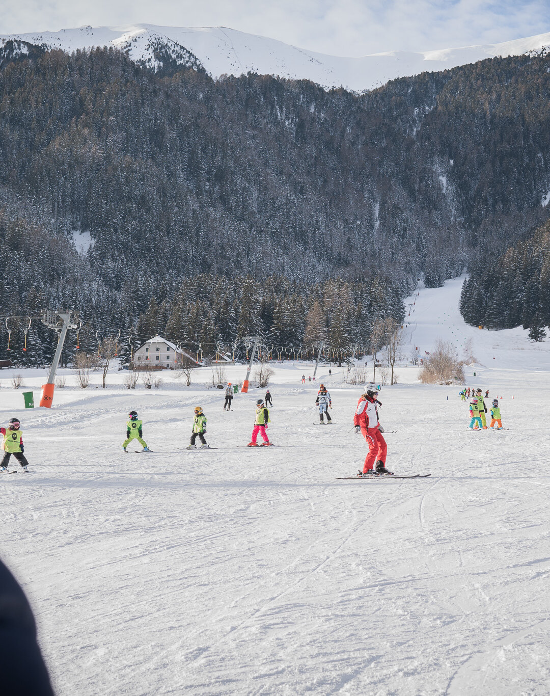 Eine Person schaut den Skifahrern auf der Piste beim Skifahren zu. | © Skilift Riepen
