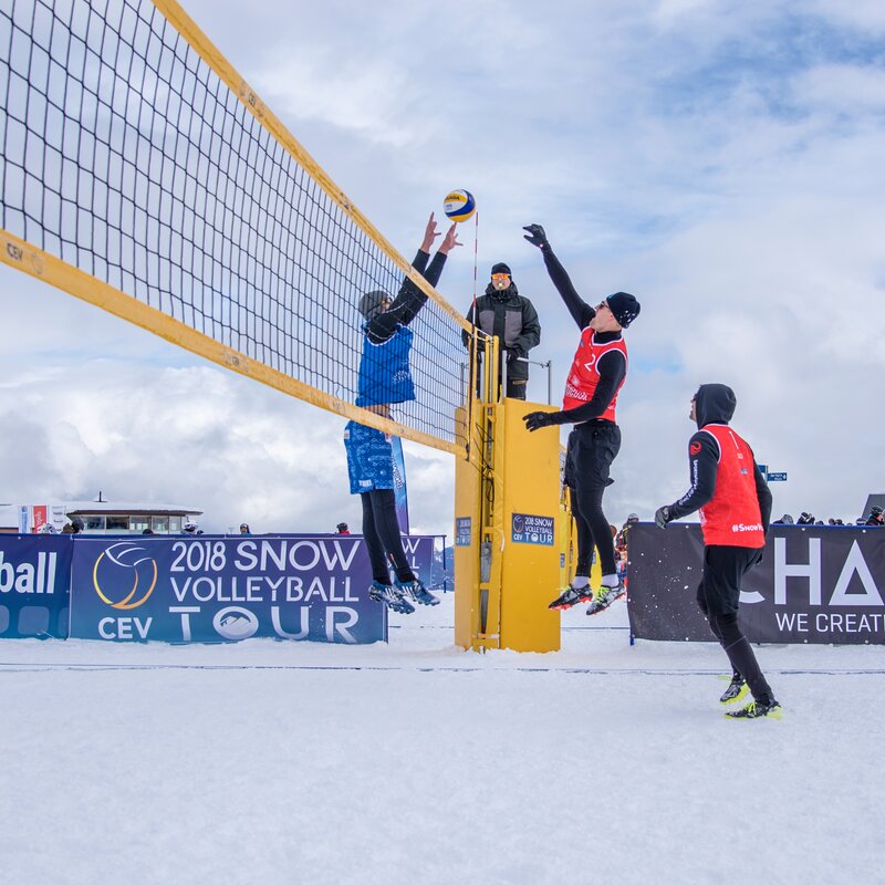 Mehrere Personen beim Snowvolleyball spielen bei bewölktem Himmel. | © Skirama Kronplatz