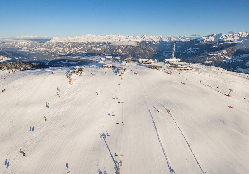Weitläufige Skipisten mit Spuren im Schnee und umliegenden Bergen bei Tageslicht. | © Harald Wisthaler