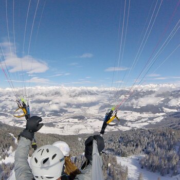 Ein Paragleiter im Winter oberhalb von Bruneck. | © Tandemflights Kronplatz