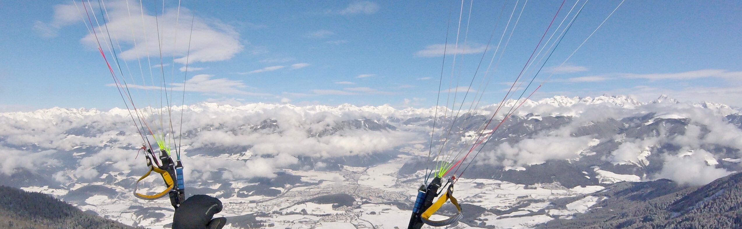 Ein Paragleiter im Winter oberhalb von Bruneck. | © Tandemflights Kronplatz