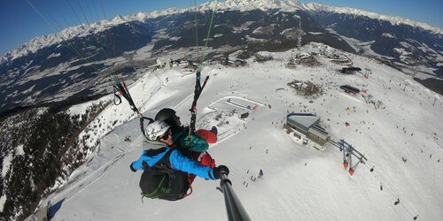 Paragleiter über dem Talkessel von Bruneck im Winter. | © Kronfly Tandem